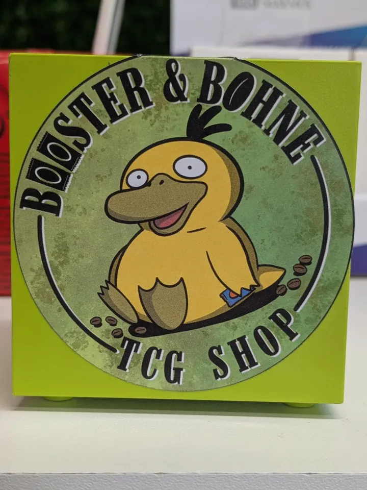 Grünes Booster-und-Bohne-Schild mit Entenmotiv auf einer Theke