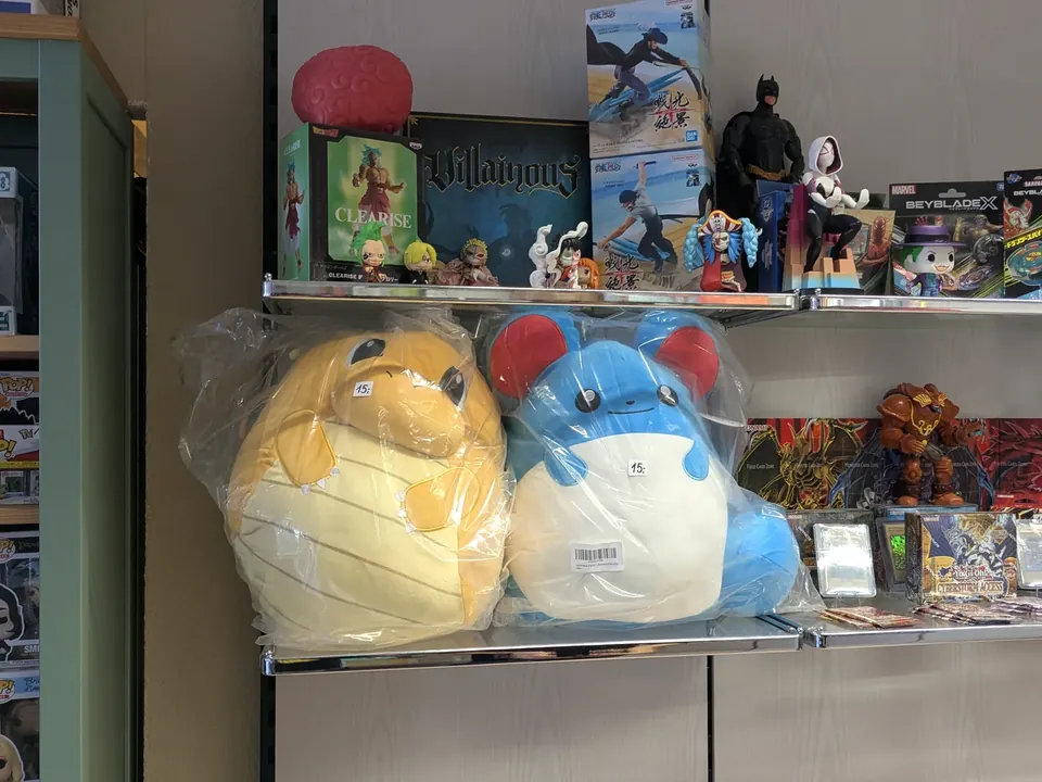 Regal mit großen Plüschfiguren, Sammelfiguren und TCG-Produkten