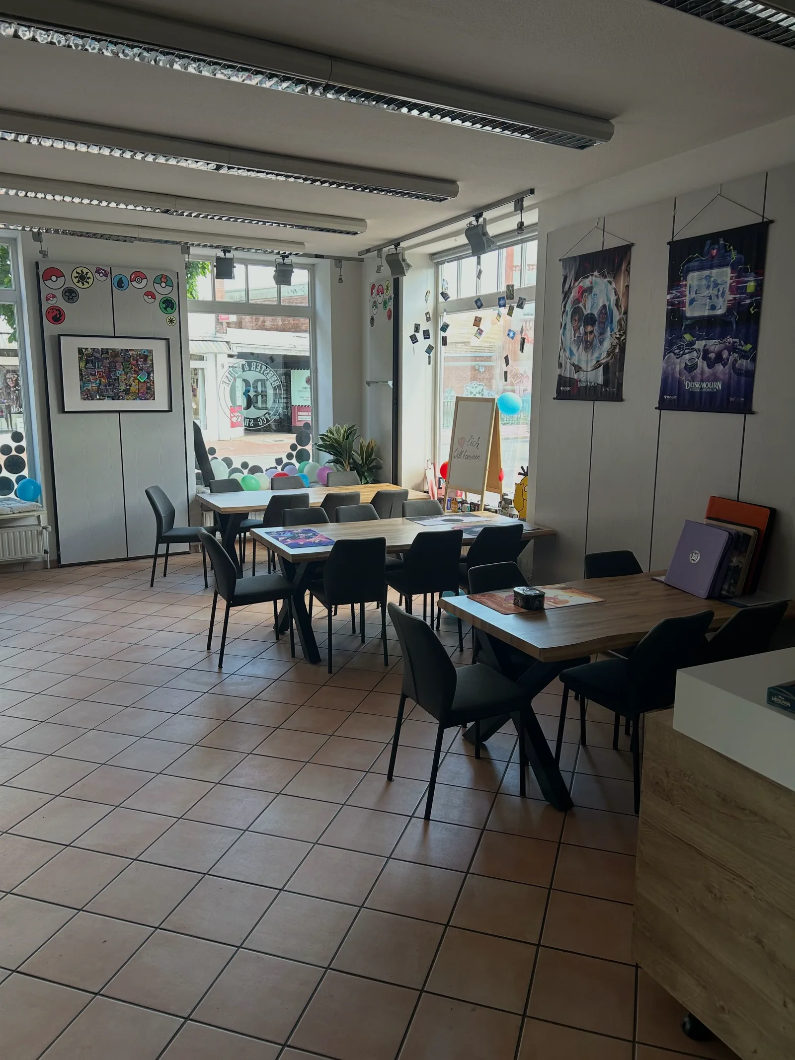 Blick in den Laden von Booster und Bohne mit mehreren Spieltischen und Sitzplätzen